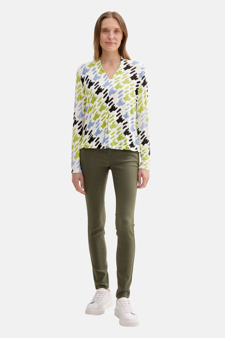 Multikleuren T-shirt met lange mouwen van Tom Tailor, met een geometrisch patroon, gedragen met een olijfgroene broek en witte sneakers.