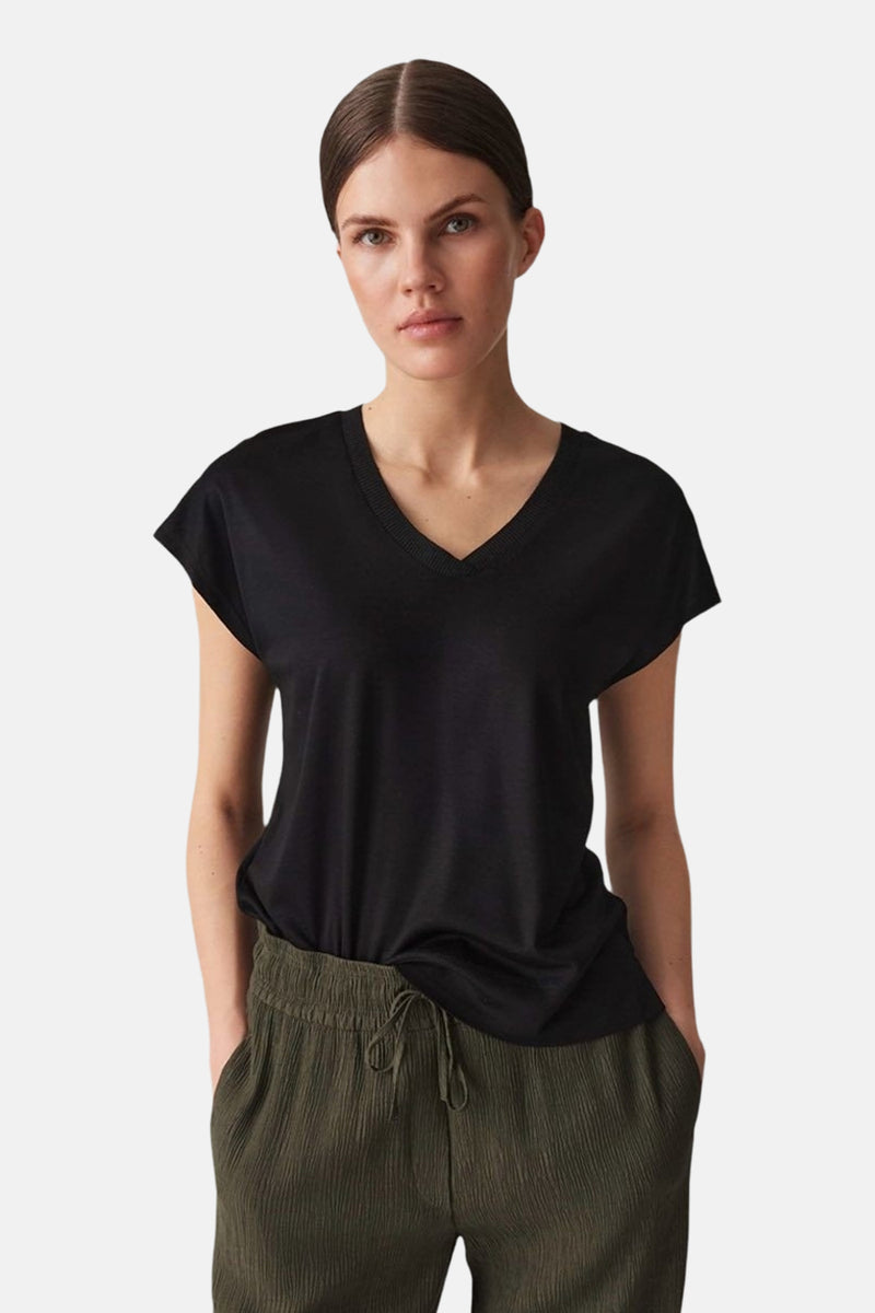 T-shirt noir à manches courtes de OPUS, porté avec un pantalon vert olive texturé à cordon.