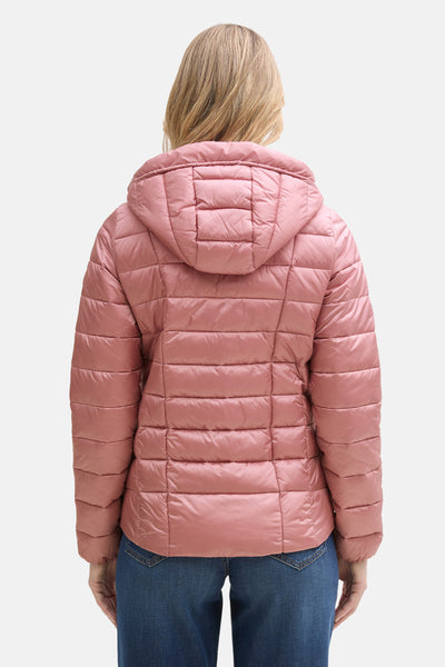 Veste courte rose par Tom Tailor avec un motif matelassé et capuche, vue de dos avec un jean porté.
