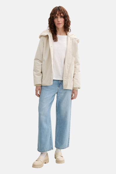 Veste courte beige de Tom Tailor, portée avec un t-shirt blanc et un jean ample bleu clair.