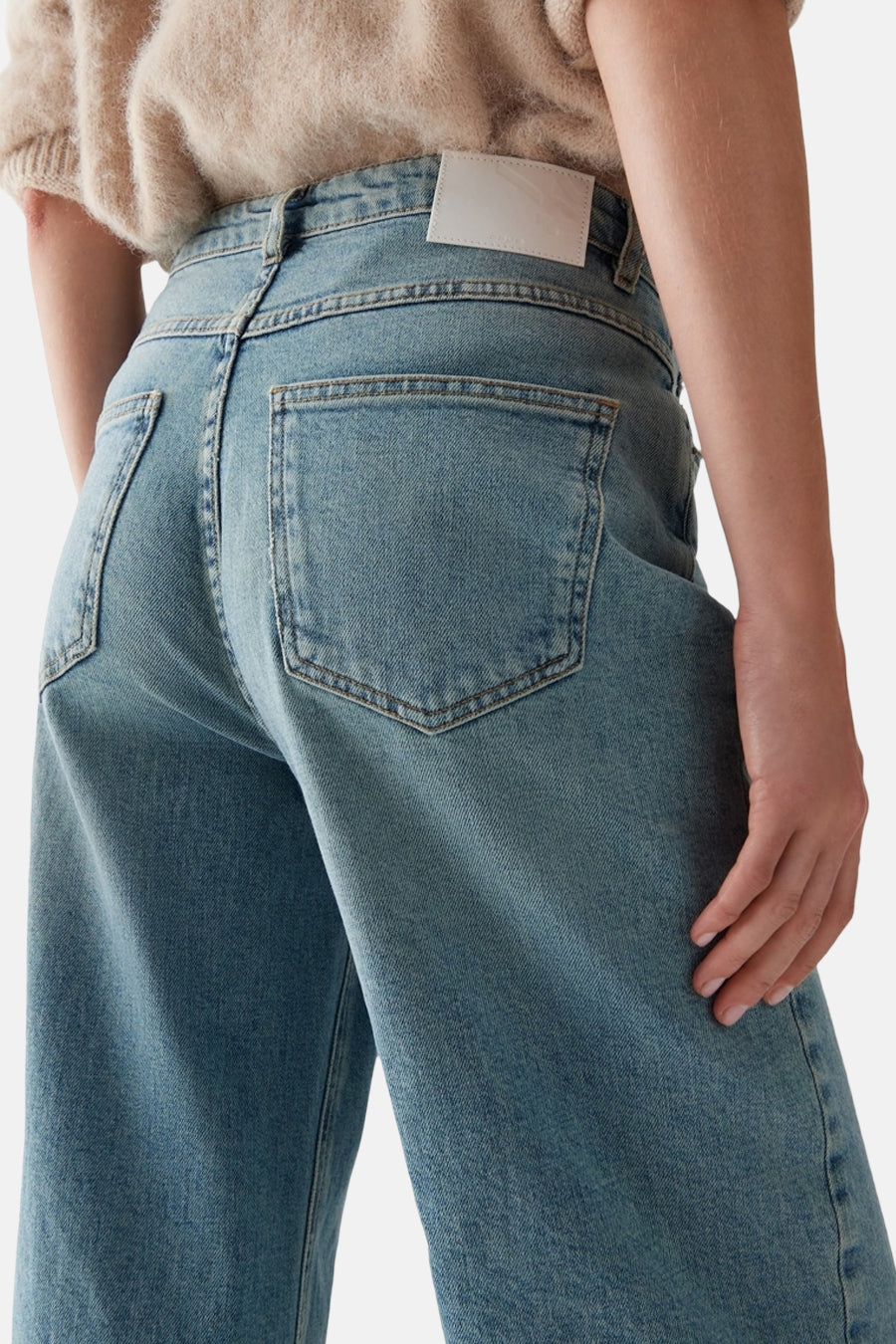 Rechte lichtblauwe denim jeans van OPUS, zichtbare achterzak, gedragen met een beige trui.