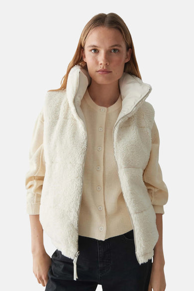 Veste sans manches écru de OPUS, avec une fermeture éclair et portée sur un cardigan.