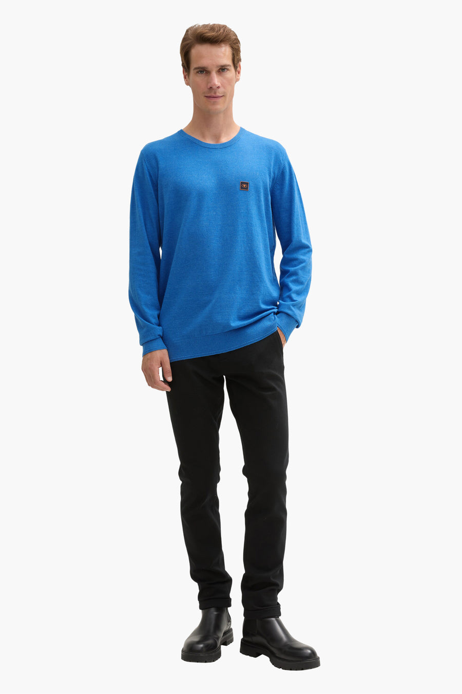 Ronde hals trui blauw van Tom Tailor, gedragen met een zwarte broek en enkellaarsjes.