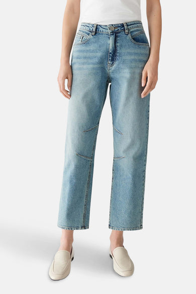 Lichtblauwe OPUS mom jeans met kniedetails en witte schoenen.
