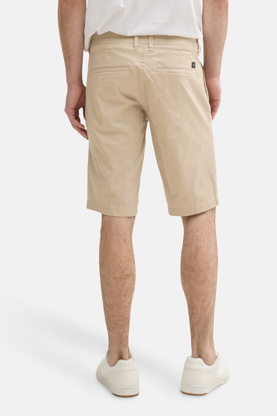 Short beige de Tom Tailor, coupe chino, avec poches arrière et porté avec un t-shirt blanc et des baskets crème.