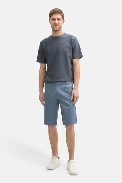 Short bleu de Tom Tailor, porté avec un t-shirt gris texturé et des baskets blanches.
