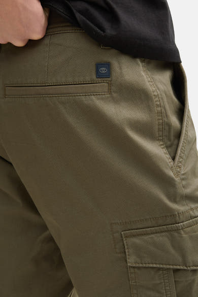 Short kaki de Tom Tailor avec poche cargo et texture subtile, porté avec un t-shirt noir.