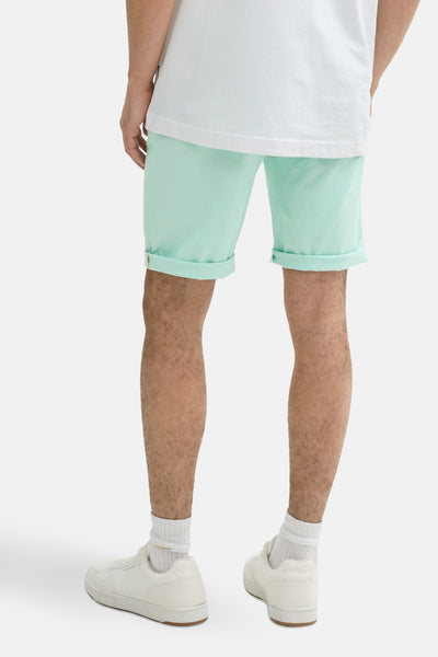 Short vert menthe de Tom Tailor, avec ourlets retroussés, porté avec un t-shirt blanc et des baskets.