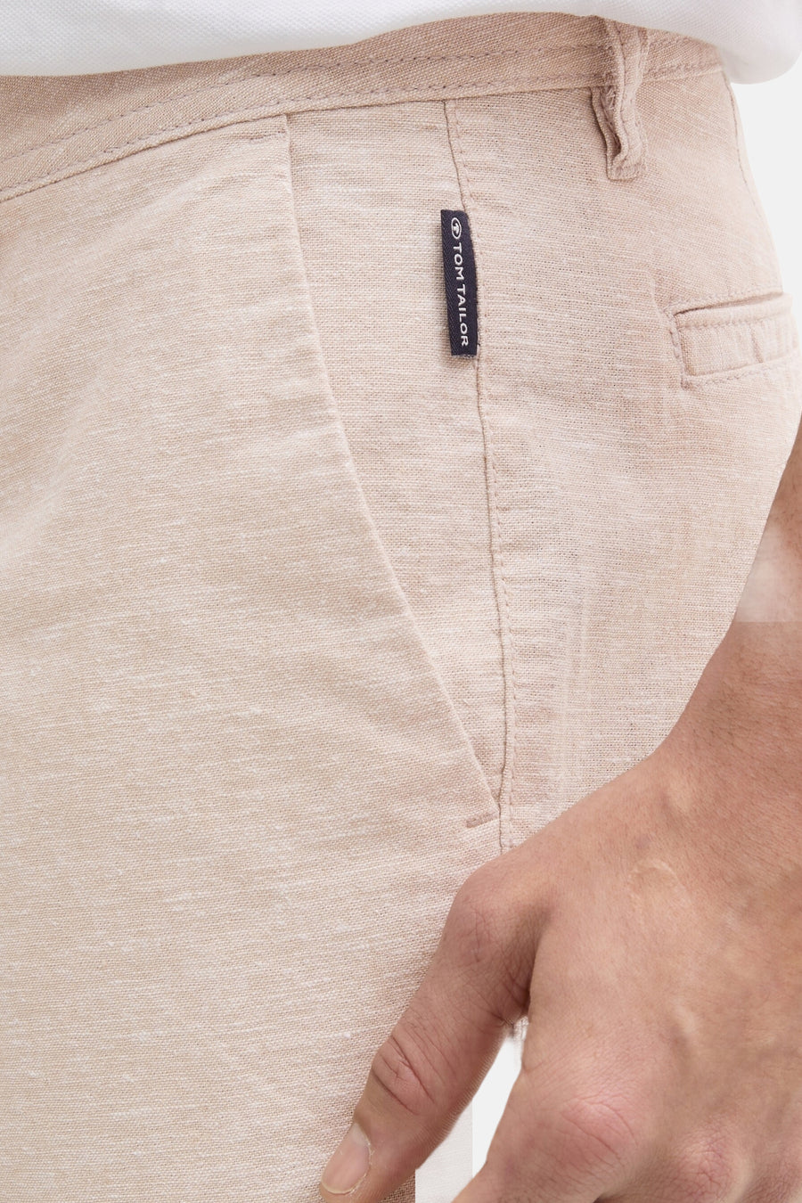 Korte beige linnen short van Tom Tailor, met een zichtbaar logolabel en de textuur van de stof in close-up.