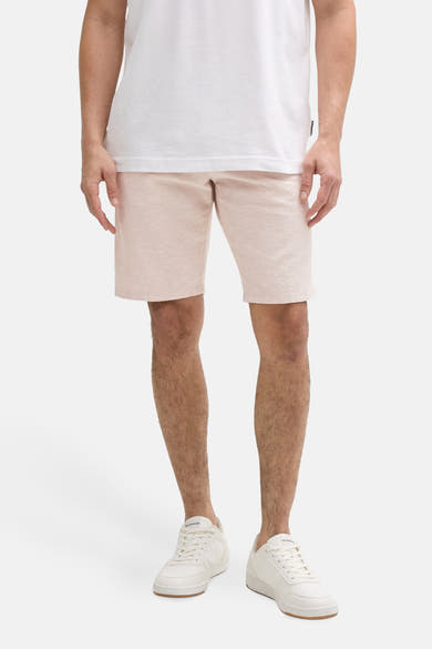 Korte beige short van Tom Tailor, boven de knie, gedragen met een wit T-shirt en witte sneakers.