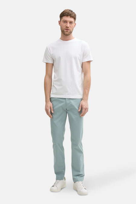 Grijze chino van Tom Tailor gedragen met een wit T-shirt en witte sneakers.