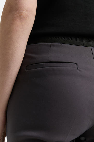 Grijze broek van Tom Tailor, met een paspelzak achter en een zwarte elastische tailleband.