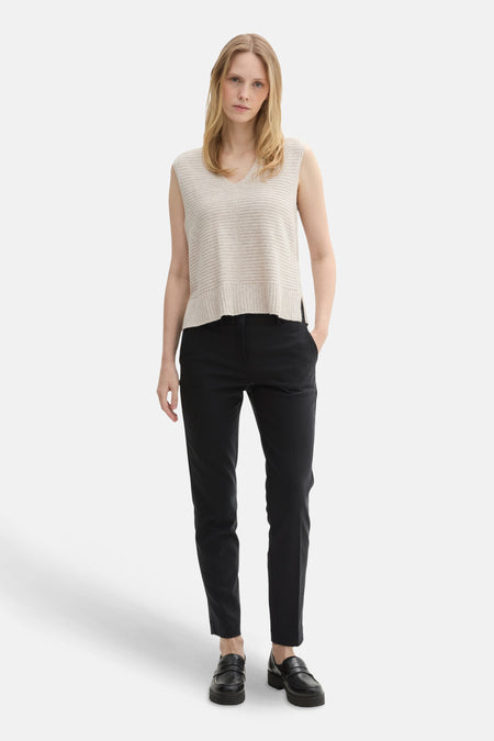 Zwarte broek van Tom Tailor, gedragen met een mouwloze trui en plateau-loafers.