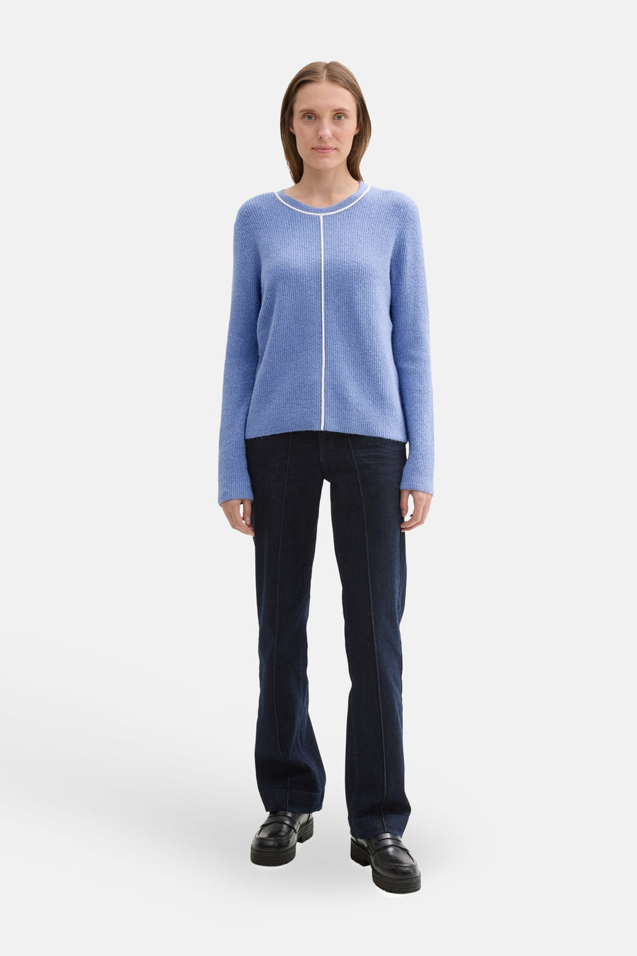 Blauwe trui met ronde hals van Tom Tailor, met een witte verticale streep, gedragen met een uitlopende spijkerbroek en loafers.
