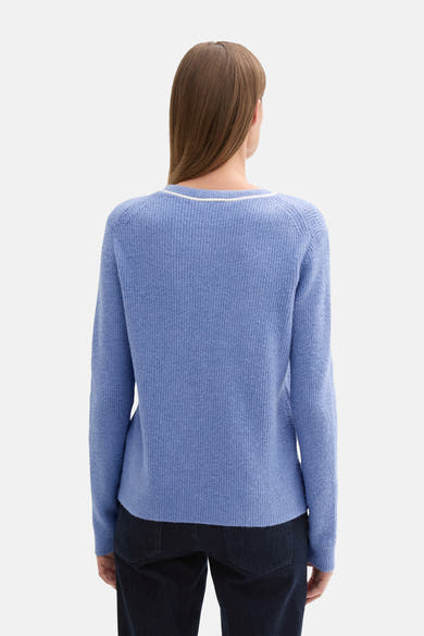Ronde hals trui blauw van Tom Tailor, met witte rand bij de hals en gebreide textuur, gedragen met een donkere broek.