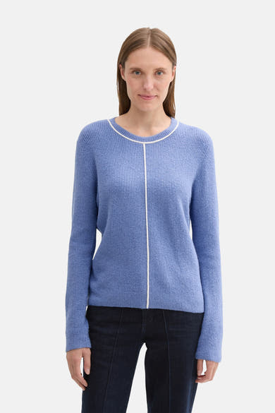 Ronde hals trui blauw van Tom Tailor, met een witte decoratieve streep op de voorkant en gedragen met een donkere jeans.