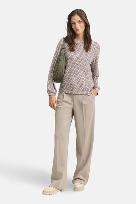 Bruin T-shirt met lange mouwen van Tom Tailor, met geometrisch patroon, gedragen met een beige broek en een groene handtas.