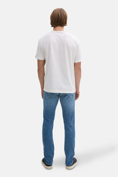 Blauwe denim slim fit jeans van Tom Tailor, achterkant, gedragen met een wit T-shirt en donkere schoenen.