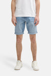 Short en denim bleu clair de Tom Tailor, avec revers aux ourlets, porté avec un t-shirt blanc et des baskets blanches.
