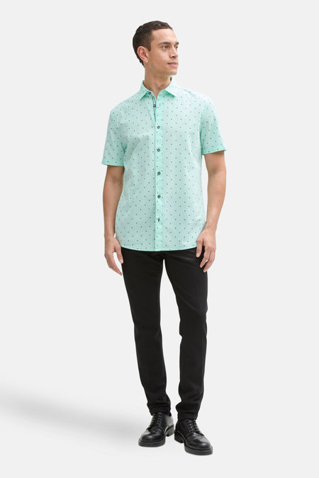 Groen overhemd met korte mouwen van Tom Tailor, met print, gedragen met een zwarte broek en zwarte nette schoenen.