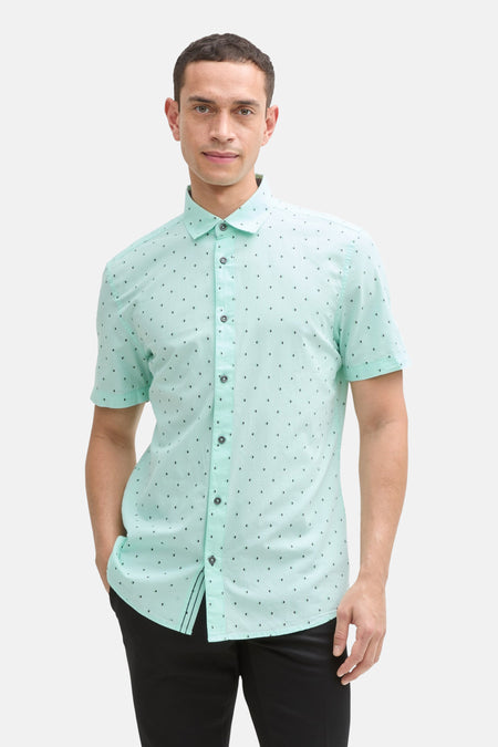 Groen overhemd met korte mouwen van Tom Tailor, met zwart driehoekig patroon, gedragen met een zwarte broek.