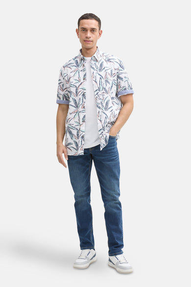 Multikleurig overhemd met korte mouwen van Tom Tailor, met een tropische print, gedragen met een wit T-shirt en een spijkerbroek.