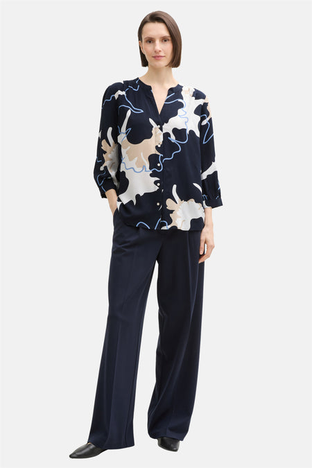 Chemisier à manches longues multicolore de Tom Tailor, avec motif abstrait et pantalon bleu marine assorti.
