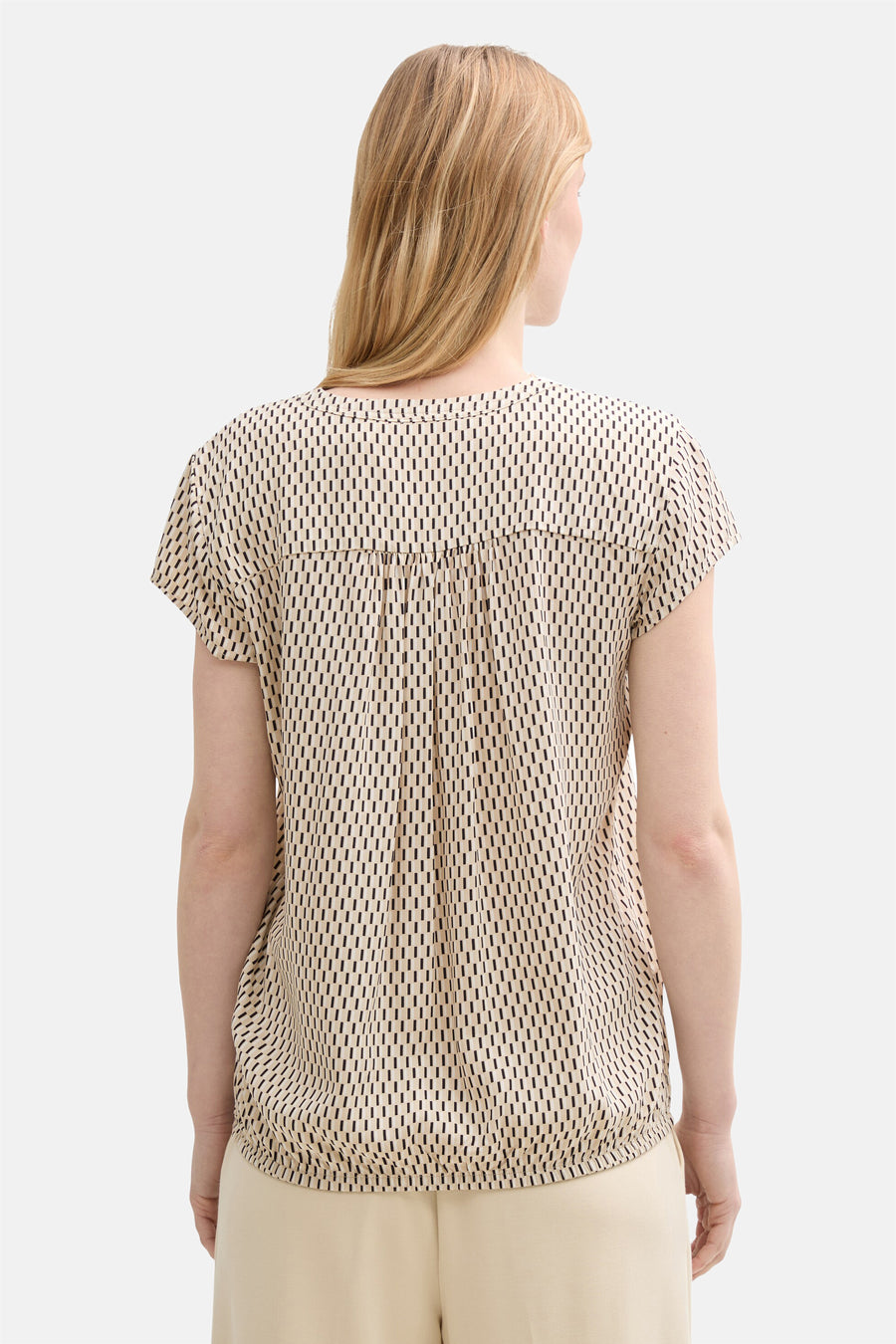 Beige blouse met korte mouwen van Tom Tailor, met een geometrisch patroon van zwarte lijnen op een beige achtergrond.