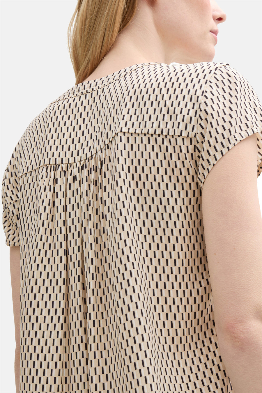 Beige blouse met korte mouwen van Tom Tailor, met een herhalend geometrisch patroon van zwarte en beige strepen.