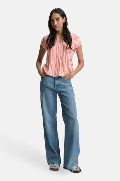 Blouse à manches courtes rouge à carreaux de Tom Tailor, portée avec un jean taille haute ample et des sandales.
