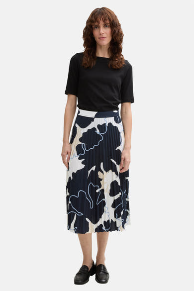 3/4 meerkleurige rok van Tom Tailor, marineblauw abstract bloemenpatroon, geplooid en gedragen met een zwart T-shirt en zwarte schoenen.