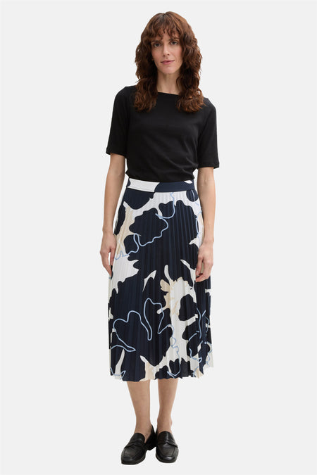 3/4 meerkleurige rok van Tom Tailor, marineblauw abstract bloemenpatroon, geplooid en gedragen met een zwart T-shirt en zwarte schoenen.