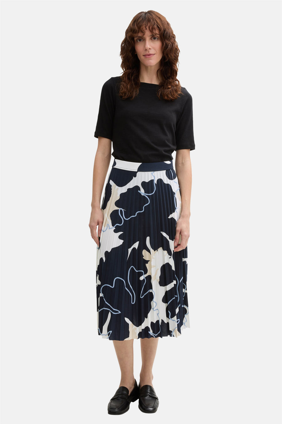 3/4 meerkleurige rok van Tom Tailor, marineblauw abstract bloemenpatroon, geplooid en gedragen met een zwart T-shirt en zwarte schoenen.