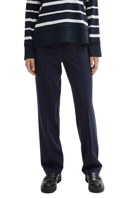Marineblauwe pantalon met rechte pijpen van Tom Tailor, gedragen met een gestreepte trui en zwarte loafers met dikke zool.