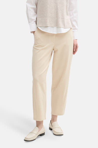 Beige 7/8 chino van Tom Tailor, met opgestikte zakken aan de achterkant, gedragen met een mouwloos vest.