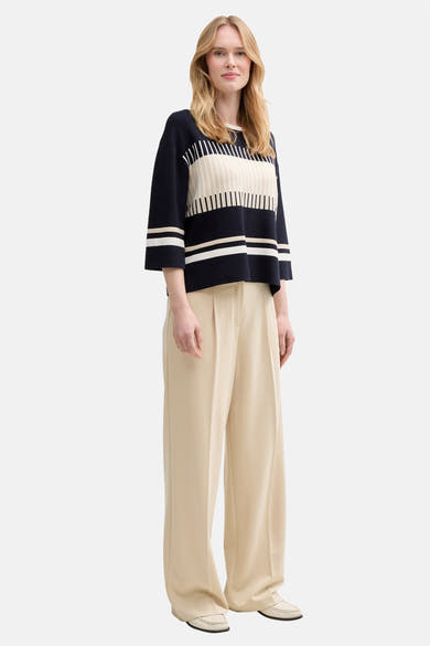 Ronde hals trui blauw van Tom Tailor met horizontale strepen, gedragen met een wijde beige broek en loafers.