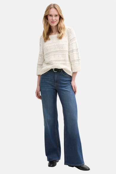 Pull à col rond écru de Tom Tailor, avec un motif ajouré et porté avec un jean taille haute et une ceinture noire.
