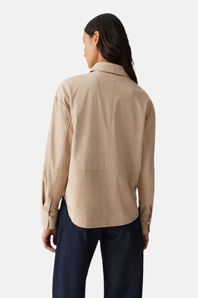Chemise à manches longues beige d'OPUS, vue de dos, portée avec un pantalon bleu foncé.