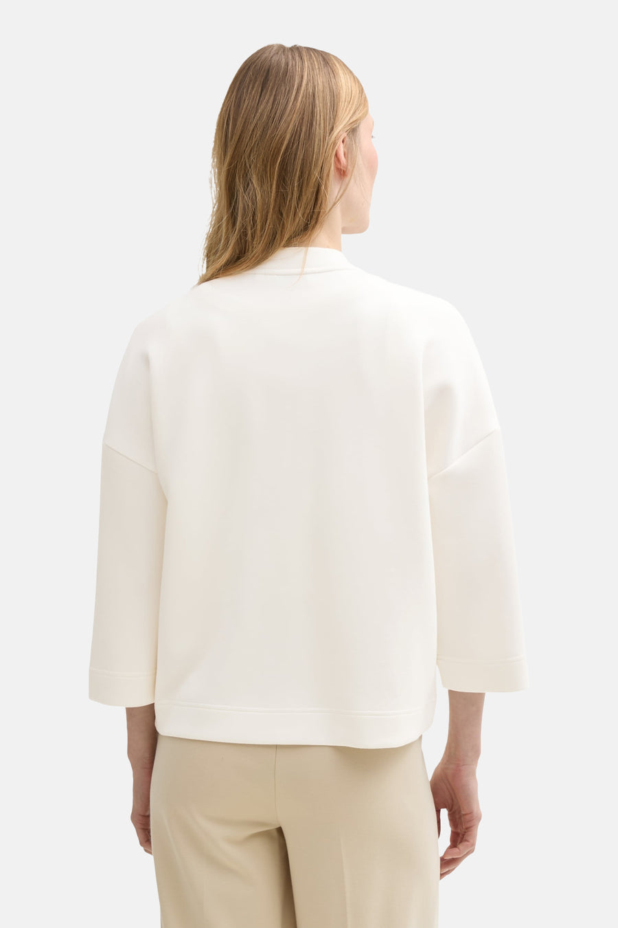 Witte Tom Tailor sweatshirt met driekwartmouwen, gedragen met een beige broek.