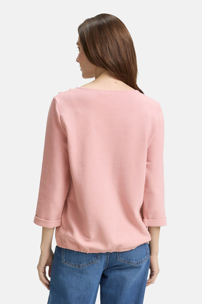 Sweat rose de Tom Tailor, à manches trois-quarts retroussées et taille élastiquée, porté avec un jean bleu.
