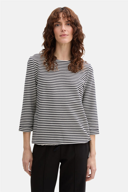 Blauw-wit gestreept T-shirt met lange mouwen van Tom Tailor, gedragen met een zwarte broek.