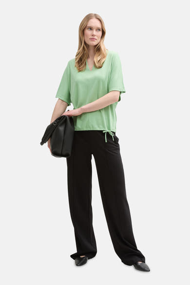 T-shirt vert à manches courtes de Tom Tailor, porté avec un pantalon noir et un sac à main.