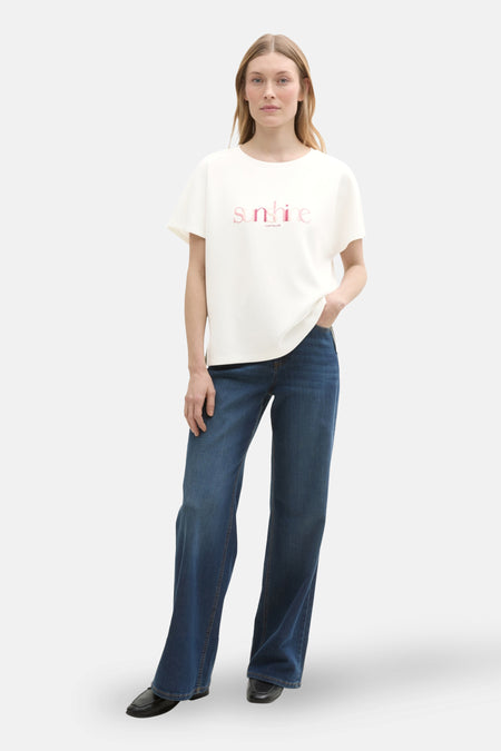 Ecru T-shirt met korte mouwen van Tom Tailor, met een roze "sunshine" print, gedragen met een spijkerbroek en zwarte schoenen.