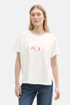 Ecru T-shirt met korte mouwen van Tom Tailor, versierd met een roze "sunshine" motief en gedragen met een spijkerbroek.