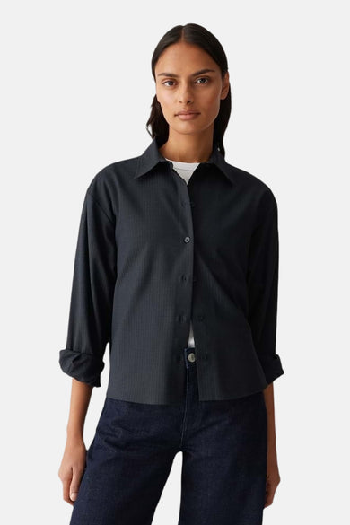Chemise à manches longues bleue par OPUS, portée ouverte sur un t-shirt blanc et un jean bleu foncé.