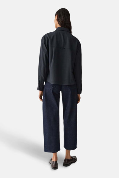 Chemise à manches longues bleue by OPUS, avec poche poitrine, portée avec un jean ample et des mocassins.