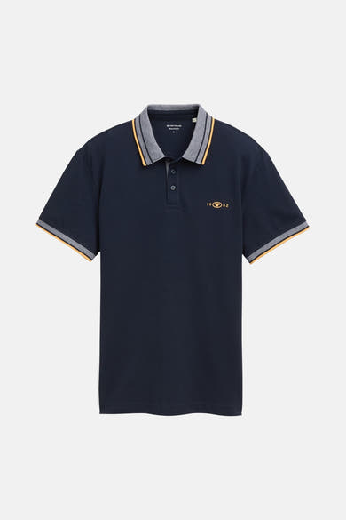 Donkerblauw poloshirt met korte mouwen van Tom Tailor, met grijs en oranje gestreepte kraag en mouwen, en gouden borduursel.