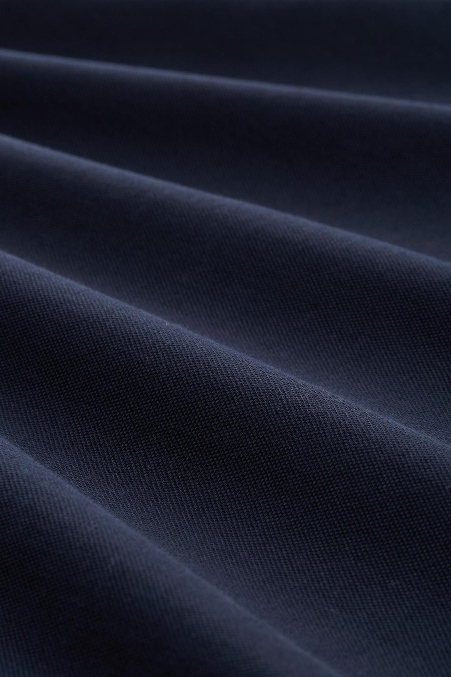 Donkerblauwe polo van Tom Tailor, in getextureerde stof met subtiele plooien.