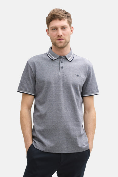 Blauw poloshirt met korte mouwen van Tom Tailor, met een gestreepte kraag en gedragen met een zwarte broek en schoenen.