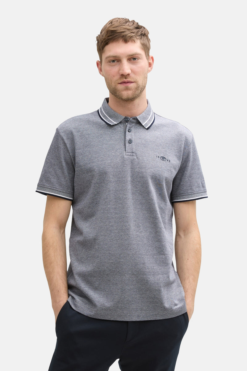 Blauw poloshirt met korte mouwen van Tom Tailor, met een gestreepte kraag en gedragen met een zwarte broek en schoenen.